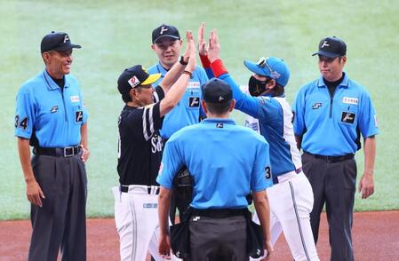 　メンバー表を交換し、小久保監督（左から２人目）と両手でハイタッチを交わす新庄監督（右から２人目）＝撮影・中島達哉