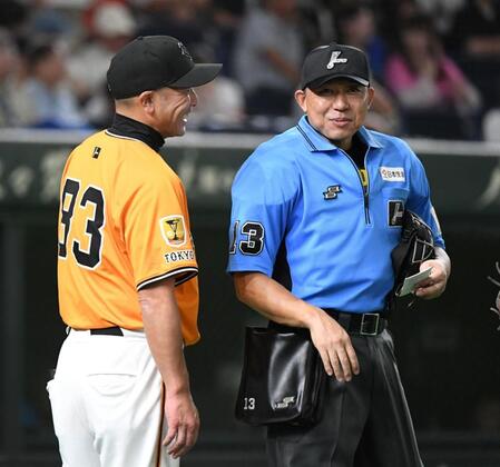 　８回、山口球審（右）に笑顔を見せながら選手交代を告げる阿部監督（撮影・佐藤厚）