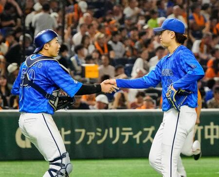 　２０セーブ目を挙げ、捕手山本（左）と握手を交わす入江