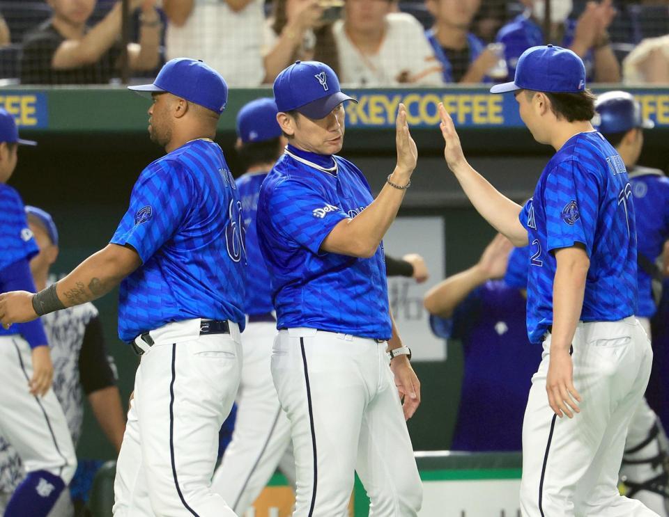 　巨人に勝利し、竹田（右）らとタッチを交わす三浦監督（中）