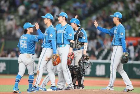 　試合に引き分けタッチをかわす日本ハムナイン（撮影・石井剣太郎）