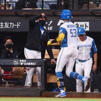 　１回、先頭打者本塁打を放った水谷（右から２人目）を迎える新庄監督（中央）＝２０日