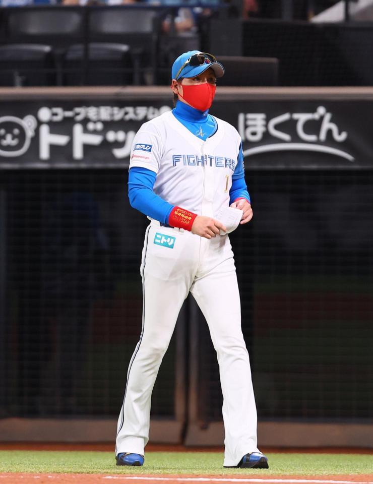 　赤いマスクでメンバー表交換に向かう新庄監督＝２０日