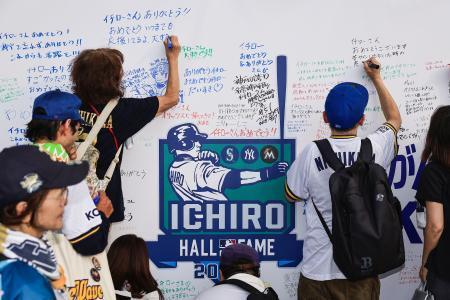 　イチローさんが米国野球殿堂入りしたことを祝い、設置された記念ボードにメッセージを書き込む人たち＝２７日、ほっともっと神戸