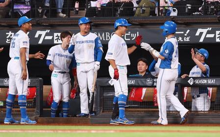 　１回、有薗（中央）の犠飛で生還した郡司（右から２人目）を迎える日本ハムナイン（撮影・中島達哉）