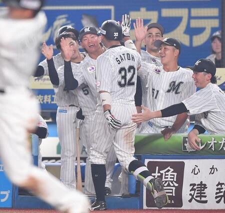 　８回、右越えソロを放ちナインとタッチを交わす佐藤（手前）＝撮影・開出牧