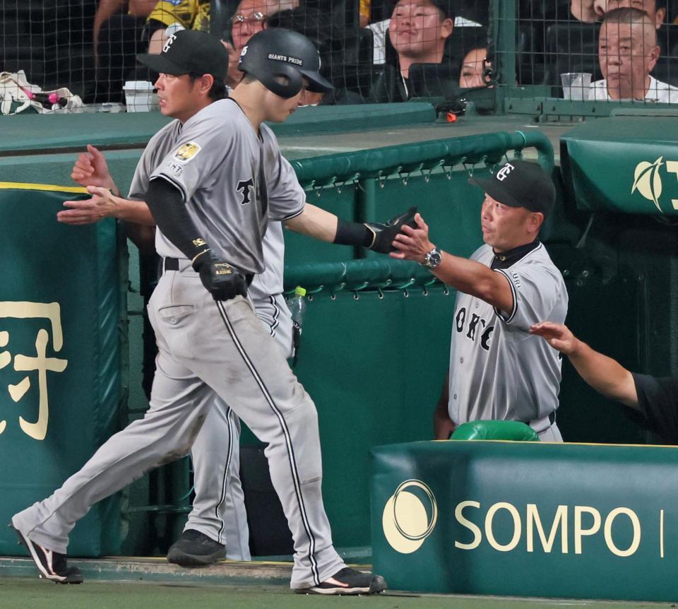 　６回、キャベッジの適時二塁打で生還した泉口（手前）とタッチをかわす阿部監督（右）＝撮影・立川洋一郎