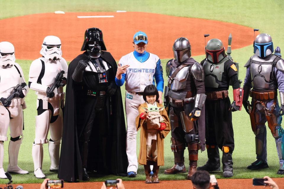 　スターウォーズのキャラクターたちと記念撮影をする新庄監督と永尾柚乃（中央）