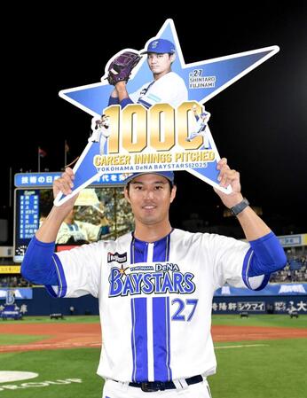 　通算１０００投球回を達成しボードを掲げる藤浪（撮影・佐藤厚）