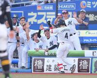 　４回、プロ初本塁打となる左越えソロを放ちナインとタッチを交わす友杉（４）＝撮影・開出牧