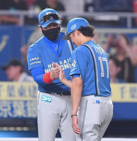 今季１３勝目を挙げた伊藤（右）とタッチを交わす新庄監督（撮影・開出牧）