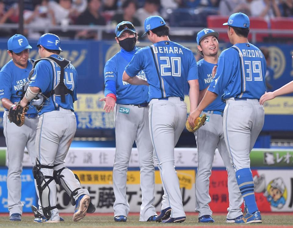 ロッテの追い上げを振り切り、上原（２０）らナインとタッチを交わす新庄監督（中央）＝撮影・開出牧