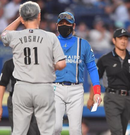 　試合前、吉井監督（手前）とメンバー表の交換を行う新庄監督（撮影・開出牧）