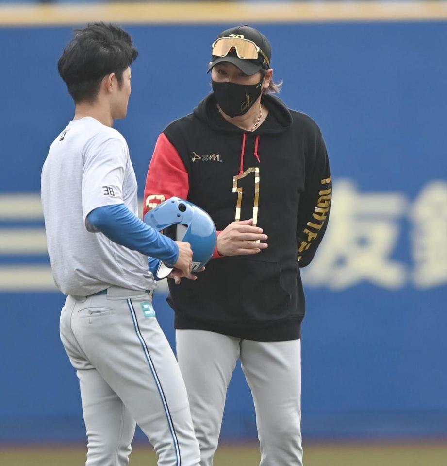 　試合前の練習で石井（左）と言葉を交わす新庄監督（撮影・開出牧）