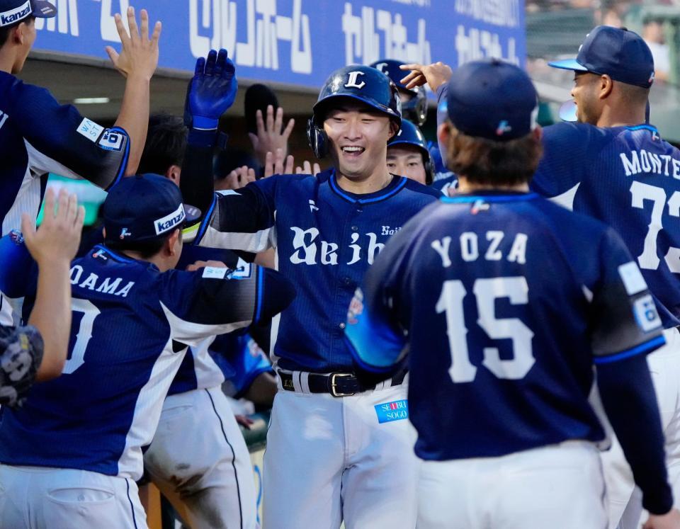 　１回、３ランを放ちナインに迎えられる山村（中央）