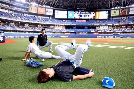 球場に到着しストレッチする伏見ら日本ハムナイン（撮影・山口登）