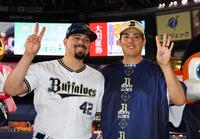 ２４セーブを飾ったマチャド（左）は九里とポーズを決める（撮影・山口登）