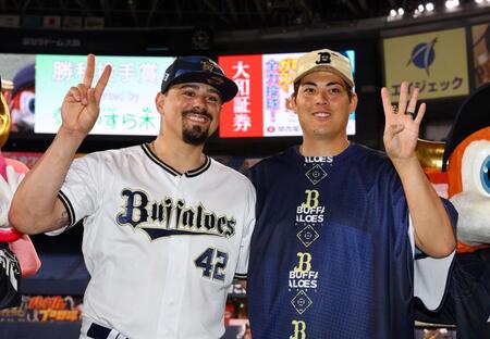 ２４セーブを飾ったマチャド（左）は九里とポーズを決める（撮影・山口登）