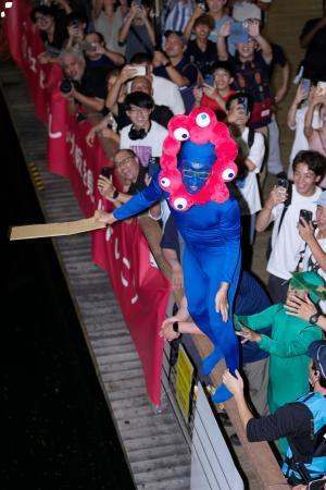 　阪神タイガースが２年ぶりのセ・リーグ優勝を決め、大阪・ミナミの道頓堀川に飛び込む大阪・関西万博の公式キャラクター「ミャクミャク」に扮（ふん）した人＝７日夜