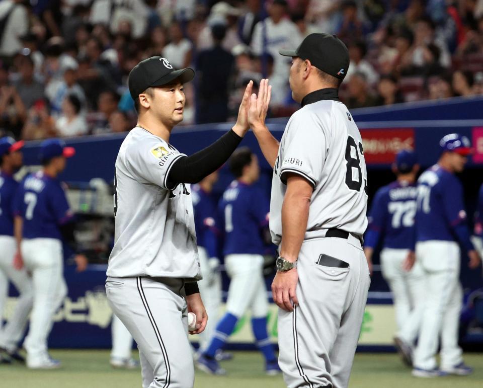 中日に勝利し、阿部監督㊨とタッチを交わす船迫　※※　＝バンテリンドームナゴヤ