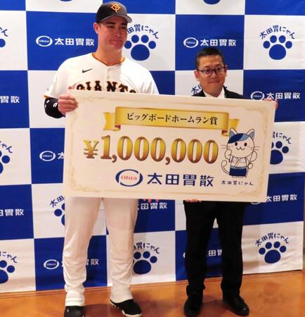　太田胃散の太田淳之社長（右）から賞金１００万円のボードが贈呈されたリチャード