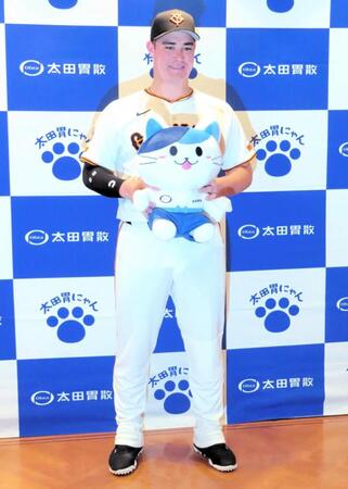 　太田胃散のマスコットキャラクター「太田胃にゃん」と記念撮影をするリチャード