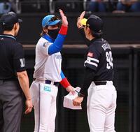 　メンバー表を交換し、小久保監督（右）とハイタッチを交わす新庄監督（中央）＝撮影・中島達哉