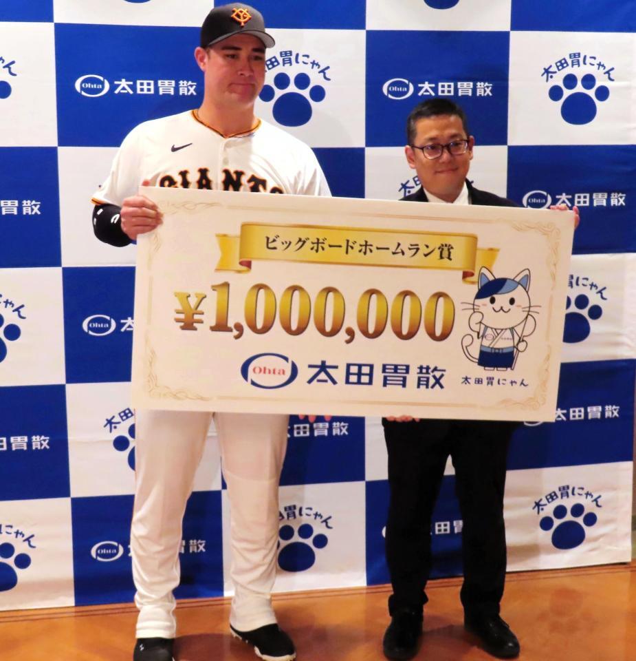 　太田胃散の太田淳之社長（右）から賞金１００万円のボードが贈呈されたリチャード