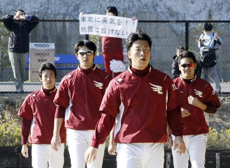 ２０１１年３月、ファンが掲げる「地震に負けない！」の幕の下で練習する（右から）楽天・田中将大、美馬学、岩隈久志ら