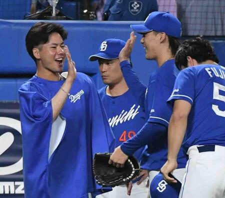 　７回、ヤクルトの反撃を１点でしのいだナインを笑顔で迎える金丸（左）＝撮影・佐藤厚