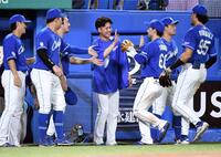 　７回、ヤクルトの反撃を１点でしのいだナインを笑顔で迎える金丸（中央）＝撮影・佐藤厚