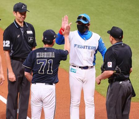 　メンバー表を交換し、岸田監督（７１）とハイタッチを交わす新庄監督（中央）＝撮影・中島達哉