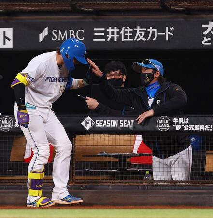 　１回、左犠飛を放つもスクイズをファウルした田宮（左）の頭をポンとたたいて迎える新庄監督（右）＝撮影・中島達哉