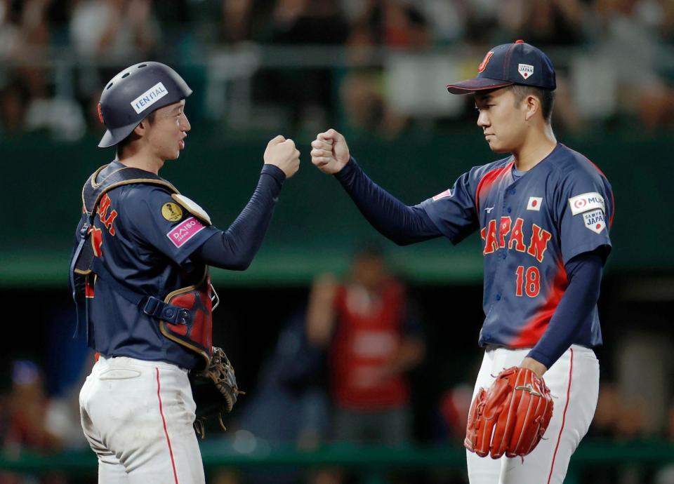 　米国に勝利し、タッチを交わす横山（左）と石垣のバッテリー