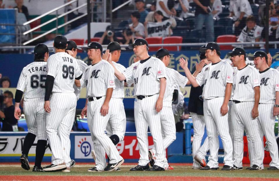 　ソフトバンクに勝利しタッチを交わす吉井監督（中央）ら