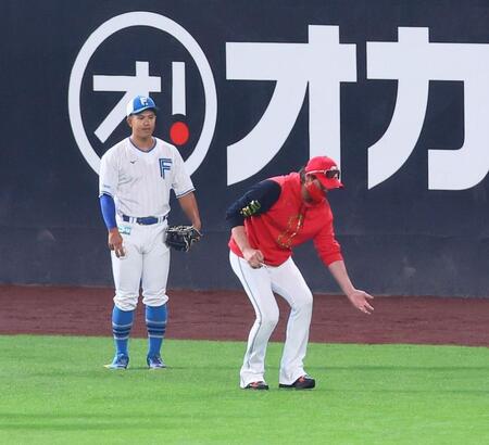 　試合前、今川（左）にスローイングの指導をする新庄監督（撮影・中島達哉）