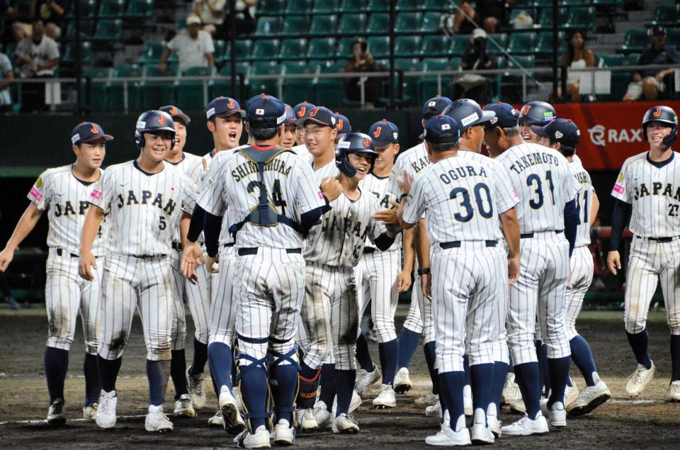 　サヨナラスクイズを決め、小倉監督（３０）らナインにたたえられる岡部（中央）