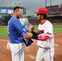 　試合終了後、サプライズで菊池から花束を受け取り、握手をする中田（撮影・市尻達拡）