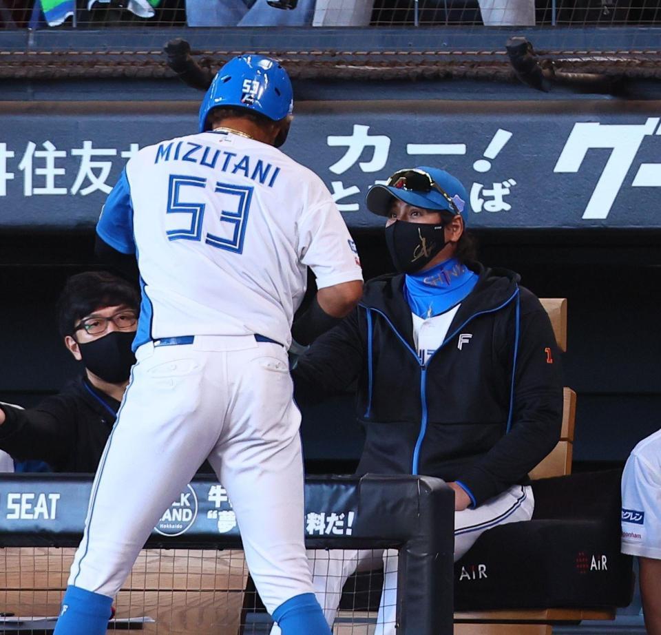 　１回、郡司の先制犠飛で生還した水谷（５３）を迎える新庄監督（撮影・中島達哉）