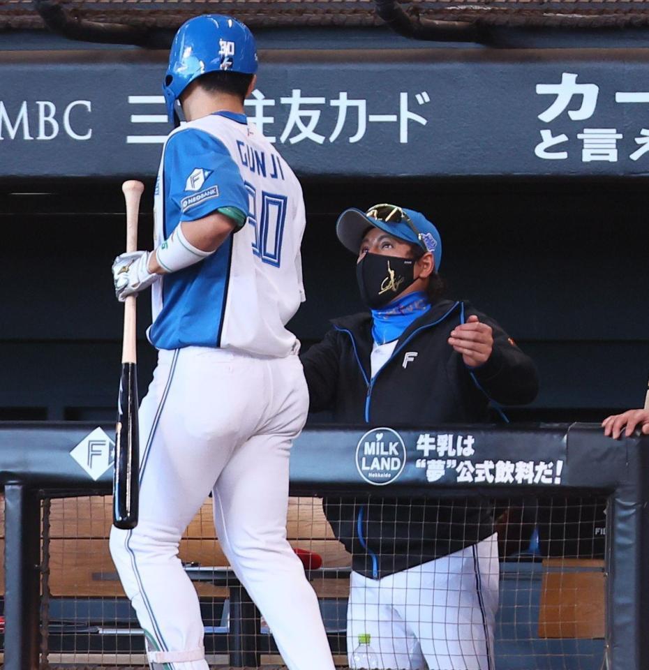 　６回、ソロを放った郡司（左）を迎える新庄監督（撮影・中島達哉）