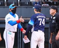 　メンバー表を交換し、握手を交わそうと手を出す新庄監督（左）とハイタッチの構えをする西口監督（中央）＝撮影・中島達哉