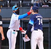 　メンバー表を交換し、笑顔で西口監督（右）とハイタッチを交わす新庄監督（撮影・中島達哉）