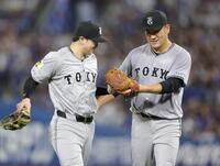 　２回を無失点に抑え、泉口（左）とタッチを交わす田中将（撮影・西岡正）