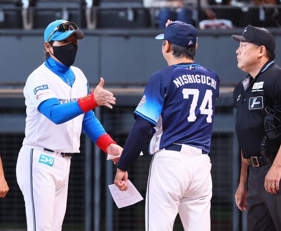 　メンバー表を交換し、握手を交わそうと手を出す新庄監督（左）とハイタッチの構えをする西口監督（中央）＝撮影・中島達哉