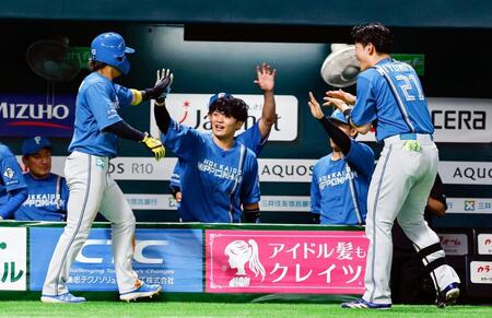 　４回、野村の中前打で生還した水野（手前左）を迎える清宮幸（右端）ら日本ハムナイン