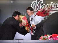 　引退会見で元ロッテで球団営業職の井上晴哉氏（左）から花束を受け取る美馬（撮影・開出牧）