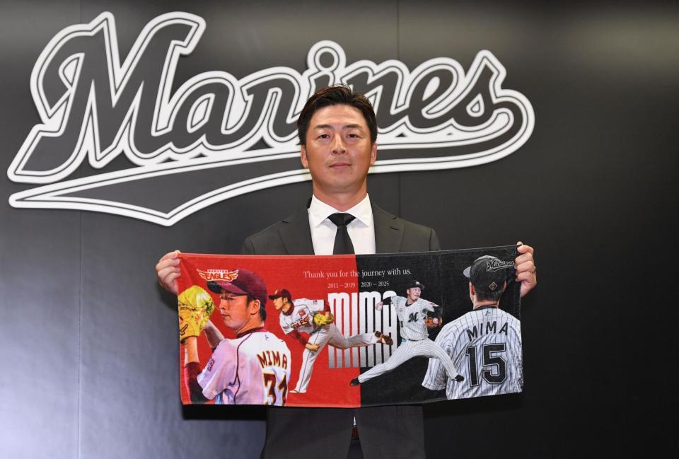 　引退グッズのタオルを手にポーズを決める美馬（撮影・開出牧）