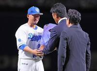 　稲葉篤紀２軍監督から花束を手渡される中田。手前は栗山英樹氏（撮影・立川洋一郎）