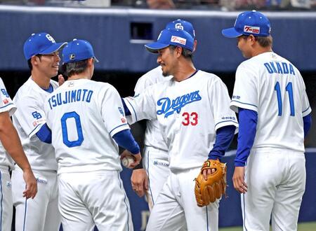 　８回、現役ラスト登板を終えナインに出迎えられる祖父江（３３）＝撮影・立川洋一郎