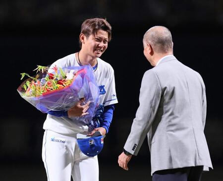 　引退セレモニーで高嶋仁・智弁和歌山高野球部名誉監督（右）から花束を受け取る岡田（撮影・立川洋一郎）